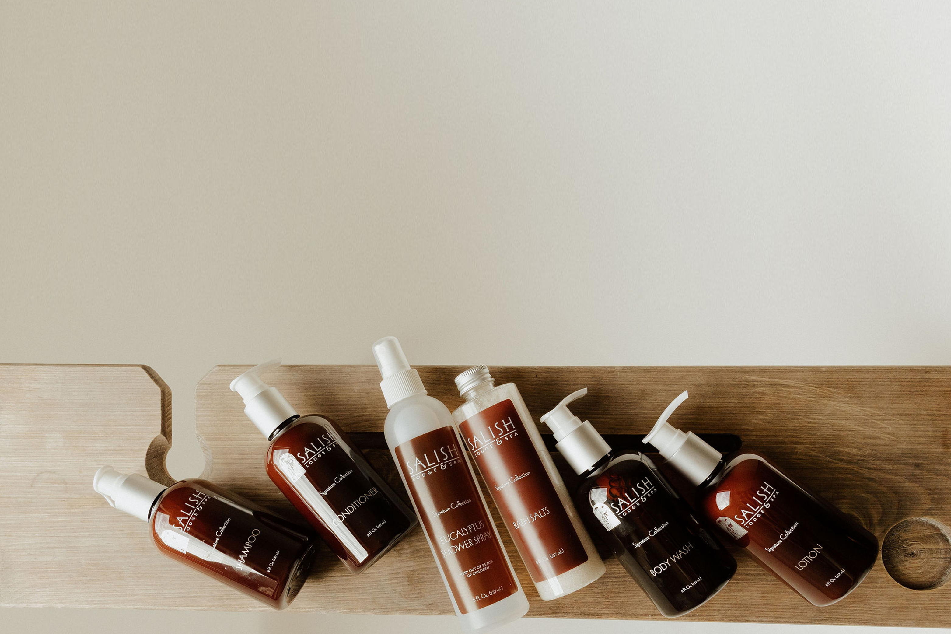 Set of skincare bottles on a wooden board with a neutral background